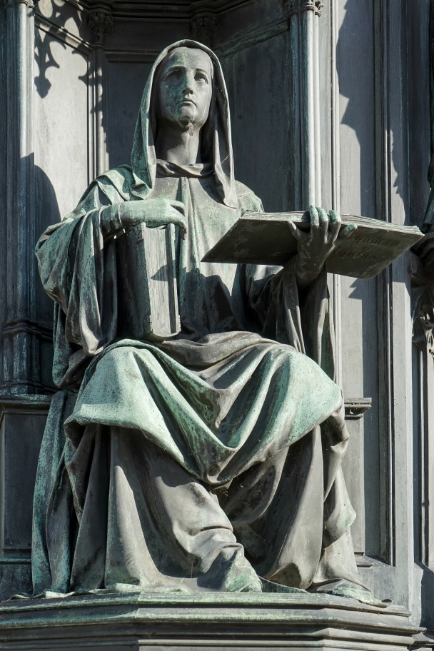 A statue of a woman holding the books of Thomas Aquinas